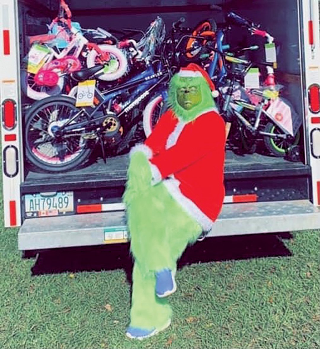The Grinch sits and waits to distribute bicycles to local children on Christmas Eve.